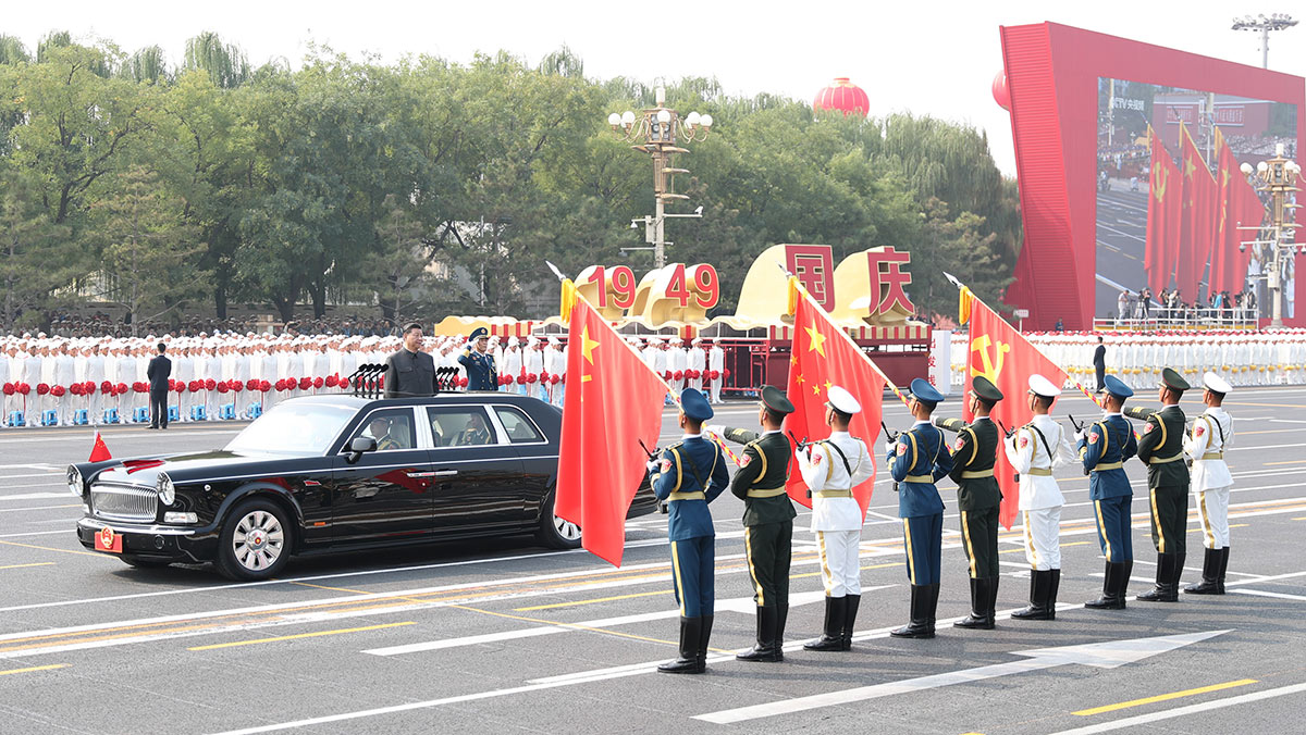 習(xí)近平驅(qū)車行進(jìn)至黨旗、國旗、軍旗前，向旗幟行注目禮